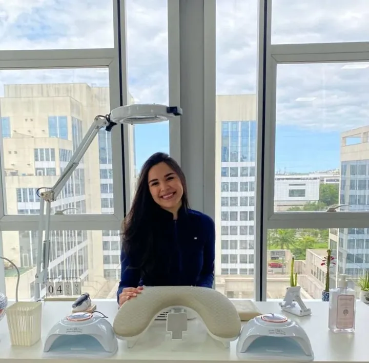 Fernanda Mezine sorrindo na mesa de atendimento